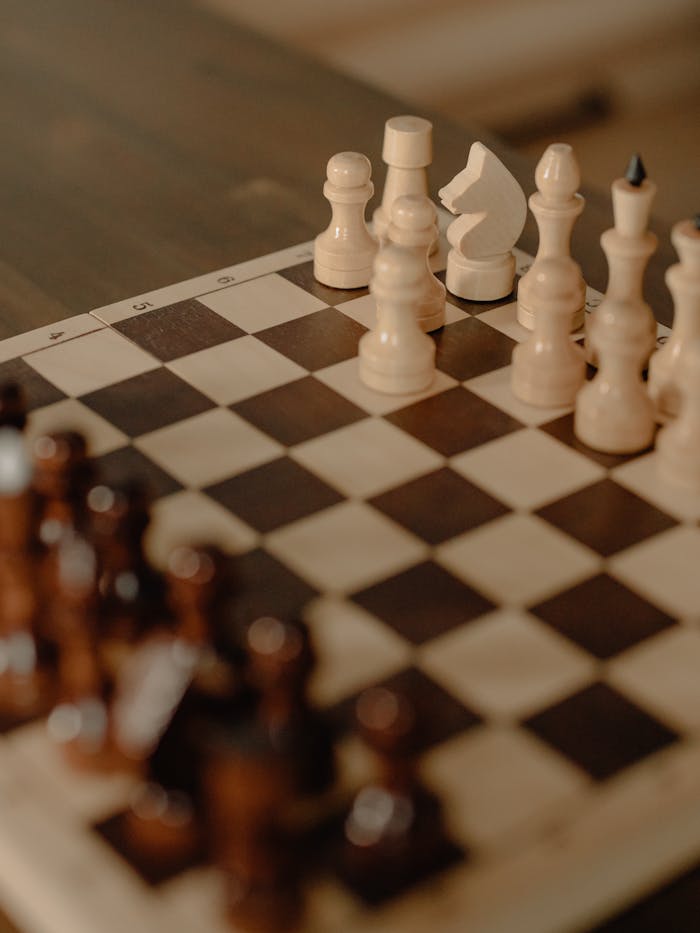 Close-up of a chessboard with strategic piece arrangement, emphasizing a cozy home setting.